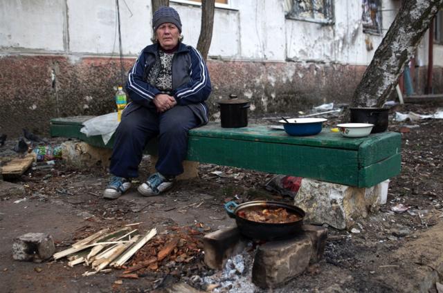Женщина готовит еду во дворе жилого дома. Вооруженные силы РФ проводят специальную военную операцию на Украине, 2 апреля