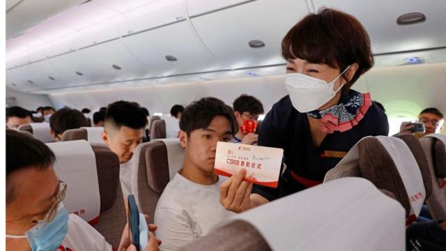 Пассажир фотографирует посадчный талон, который держит в руках стюардесса