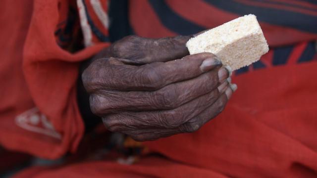 Кусок пищи в руке пожилой женщины