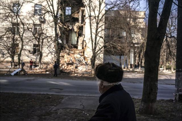мужчина на фоне разрушенного дома