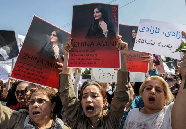 Женщы на демонстрациями с фотографиями Махсы Аминиин