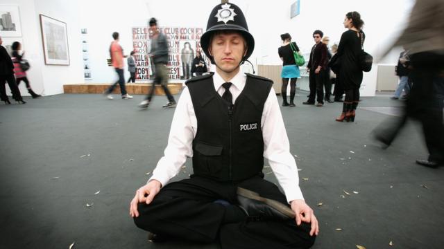 Полицейский медитирует, будучи частью инсталляции на Frieze Art Fair в октябре 2007 года в Лондоне.