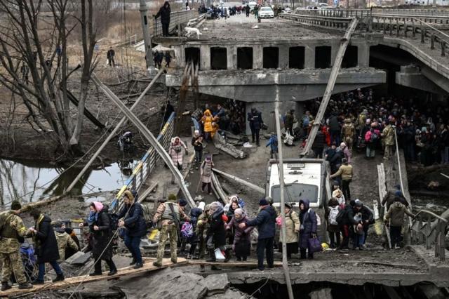 Люди перетинають зруйнований міст під час евакуації з міста Ірпінь, 5 березня 2022 року