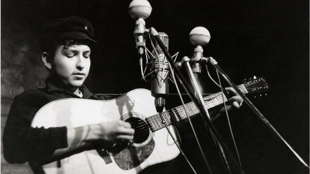 Полный желания следовать образцу своего кумира Вуди Гатри 20-летний Боб Дилан во время одного из первых выступлений в Нью-Йорке. Фолк-клуб The Bitter End folk в районе Гринич-виллидж. 1961 г