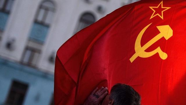 Мужчина целует флаг СССР