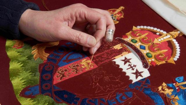 A member of the Royal School of Needlework working on the Chair of State of Queen Consort