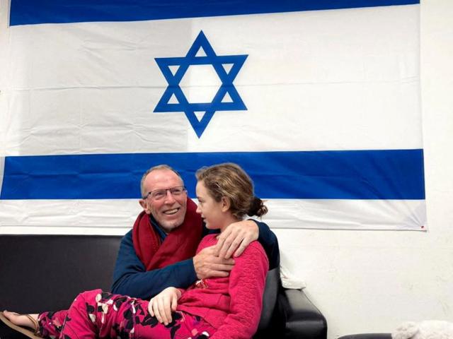 Томас с дочерью под израильским флагом