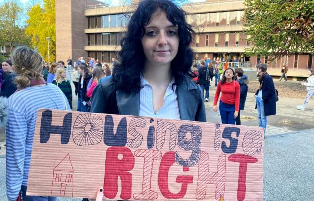 Студентка второго курса Даремского университета Рэйчел Лоуренс держит плакат: "Жилье - это наше право"