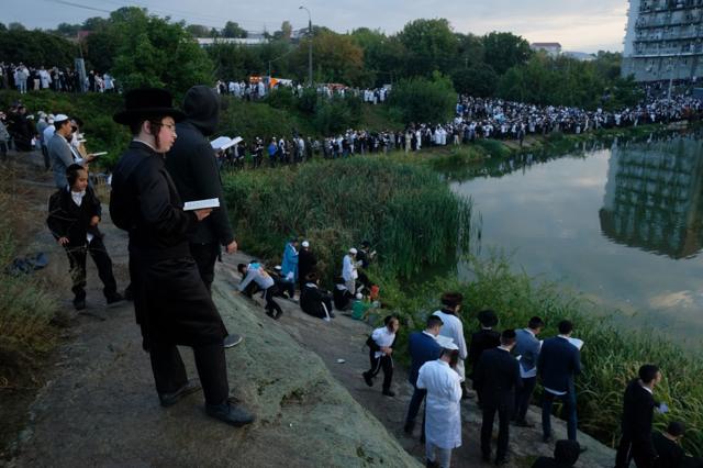 Religious Jews perform tashlikh, a Jewish atonement ritual, at a lake formed by the Umanka River on the first day of Rosh Hashanah on September 10, 2018 in Uman, Ukraine