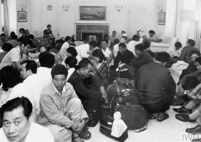 Черно-белая фотография, люди сидят на полу в гостиной яхты