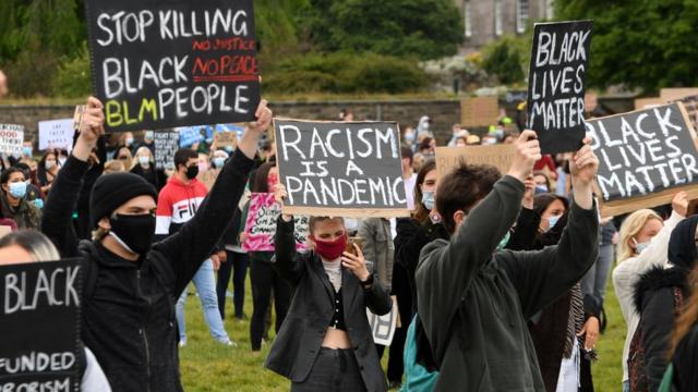 Некоторые протестующие в Эдинбурге вышли с плакатами "Расизм - это пандемия"