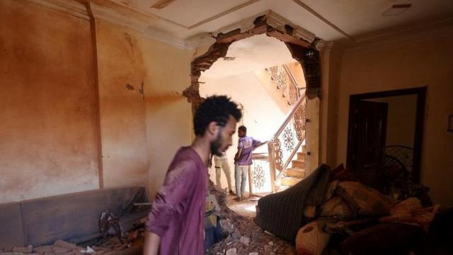 A man looks at the damage inside a house during clashes between the paramilitary Rapid Support Forces and the army in Khartoum, Sudan April 17