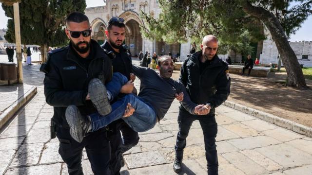 Израильские полицейские несут задержанного