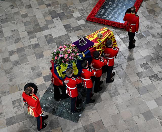 Группа носильщиков Королевской роты 1-го батальона гренадерской гвардии несет гроб королевы Елизаветы II, задрапированный королевским штандартом
