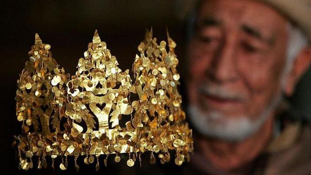 A curator of the National Museum in Kabul with the golden crown found at Tela Tepe, on display in Amsterdam in 2007