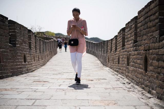 Девушка со смартфоном на Великой Китайской стене
