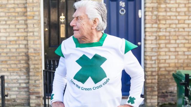 Дэвид Проуз в костюме с зеленым крестом