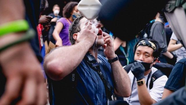 Протестующие используют молоко после применения полицией слезоточивого газа в Нью-Йорке