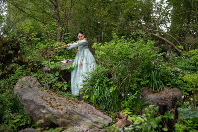 Флейтистка в традиционном корейском платье в саду