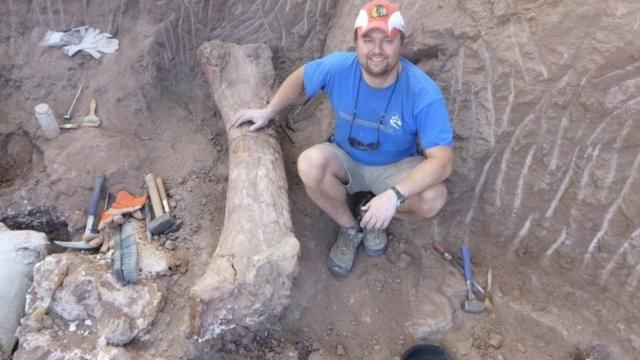 Питер Маковицки с костью, обнаруженной в песчаниках Патагонии
