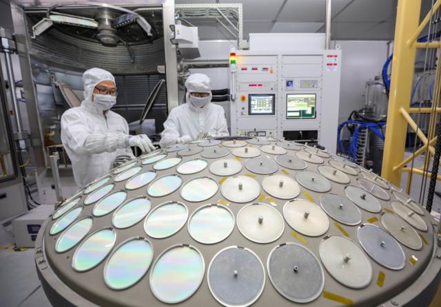 Hình ảnh công nhân làm việc trên một dây chuyền sản xuất đĩa bán dẫn ở tỉnh Giang Tô