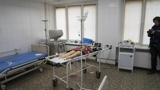 Євген Малолєтка фотографує тіло дівчинки, яка загинула внаслідок обстрілу житлового кварталу. Міська лікарня Маріуполя, 27 лютого 2022 року (фото Мстислава Чернова)