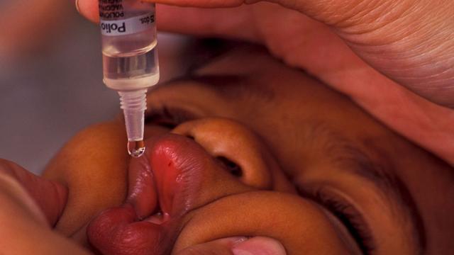 Ребенку делают прививку от полиомиелита в бразильской клинике