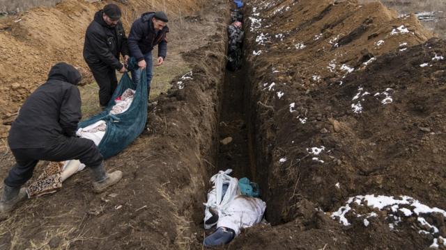 Тела погибших помещают в братскую могилу на окраине Мариуполя, 9 марта 2022 года (фотография Мстислава Чернова)