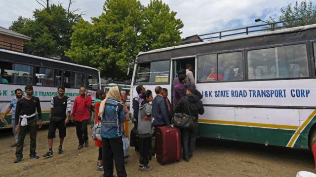 Туристы и паломники садятся в автобус в Кашмире