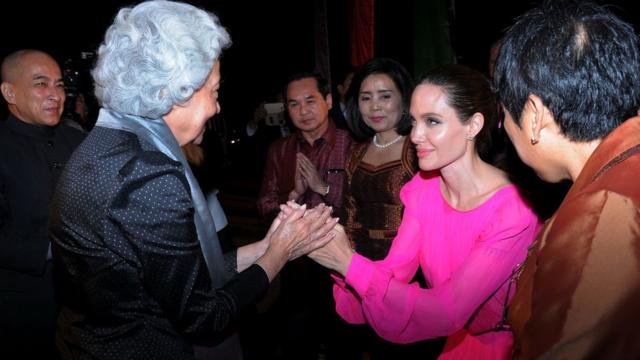 Hollywood star Angelina Jolie pays respect to Cambodian former queen Monique as Cambodian King Norodom Sihamoni looks on during the premiere of Jolie"s new film First They Killed My Father