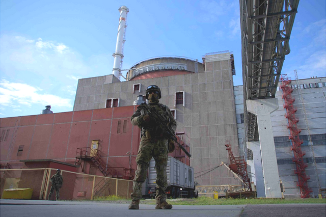 Российский военнослужащий охраняет территорию возле второго блока Запорожской АЭС в Энергодаре, 1 мая 2022