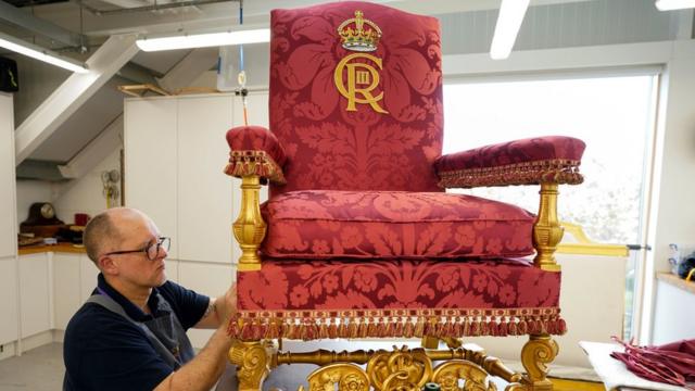 A member of the Royal Household works on the Chair of Estate for King Charles