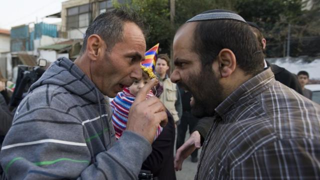 Еврейский поселенец спорит с палестинцем.