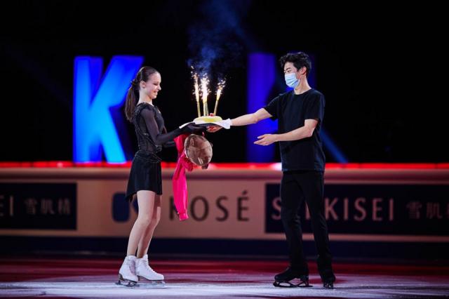 Nathan Chen of the United States hands over a birthday cake to Anna Shcherbakova of FSR performs in the Gala Exhibition