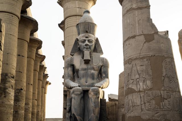 Древнеегипетская статуя на фоне колонн