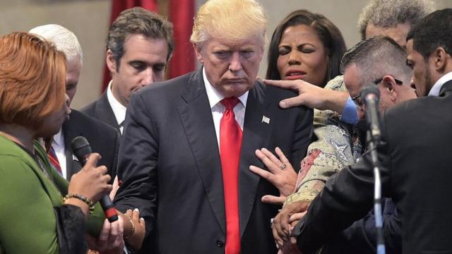 Люди прикасаются к Трампу и молятся в ходе его визита в церковь в Огайо