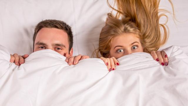 Пара в кровати под одеялом.