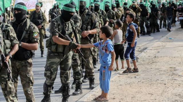 Палестинский мальчик жмет руку бойцу бригад аль Кассам