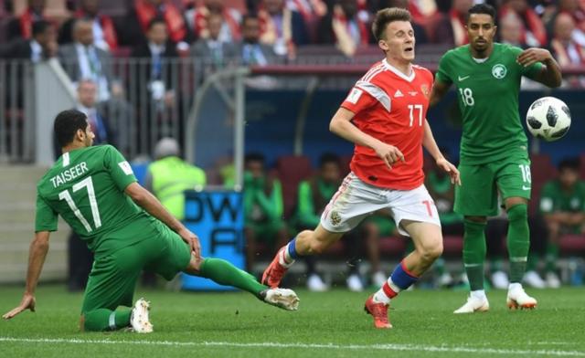 Russia's Aleksandr Golovin is tackled during the 2018 World Cup match between Russia and Saudi Arabia on 14 June, 2018