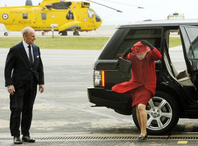 Britain's Queen Elizabeth II and the Duke of Edinburgh arrive at a windy RAF Valley in Anglesey, to visit their grandson Prince William at the base.