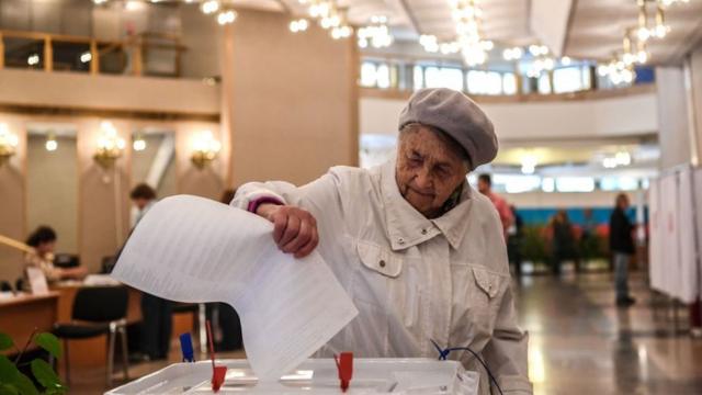 бабушка-избиратель голосует на выборах