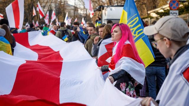 Люди з білоруськими та українськими прапорами на ході, присвяченій білоруському Дню волі. Зібрати таку ходу у Білорусі зараз неможливо. Варшава, 26 березня 2022 року
