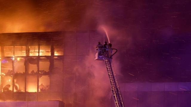 Rescuers work to extinguish fire at the burning Crocus City Hall concert venue following a shooting incident, outside Moscow, Russia