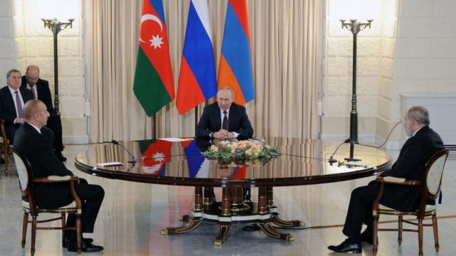 Пашинян, Алиев и Путин за столом на фоне флагов Азербайджана, Армении и России