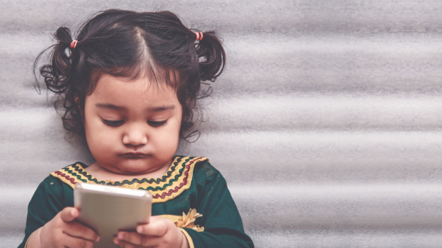 Toddler playing with a mobile phone