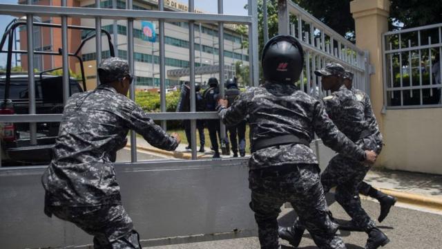 Полицейские бегут к правительственному зданию, где был убит министр Орландо Хорхе Мера.