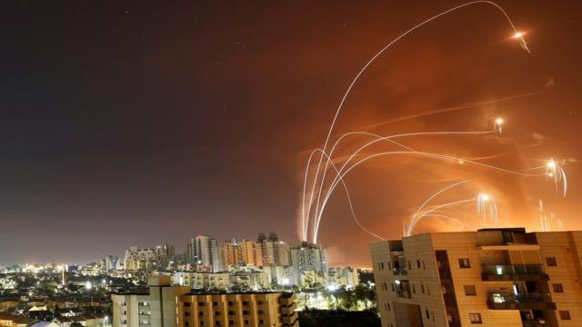 Палестинские ракеты и израильские противоракеты системы ПВО "Железный купол" в небе над городом Ашкелон в ночь на среду