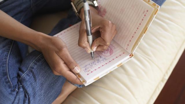 Женщина пишет в дневнике