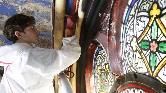 A restorer works on a stained glass window from Notre-Dame
