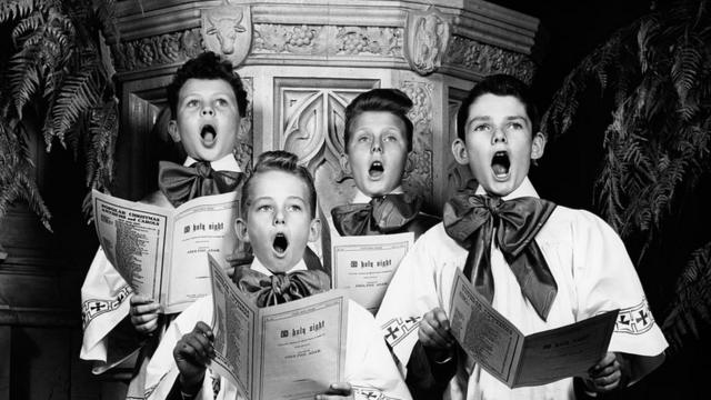 Черно-белая фотография. Хор мальчиков исполняет рождественские гимны